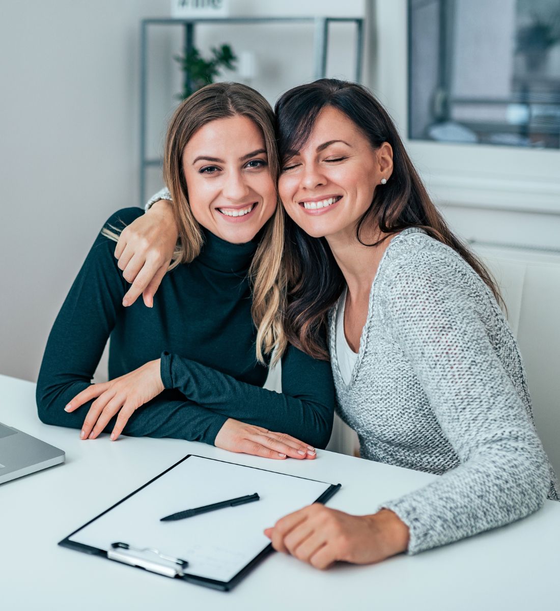 two smiling women working together