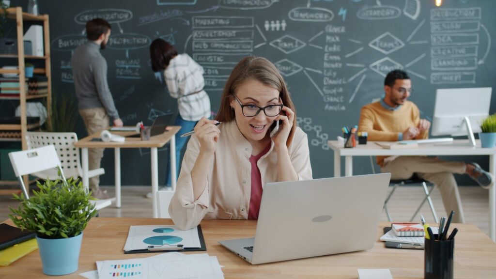 Woman talking about business stagnation solutions on phone in modern office
